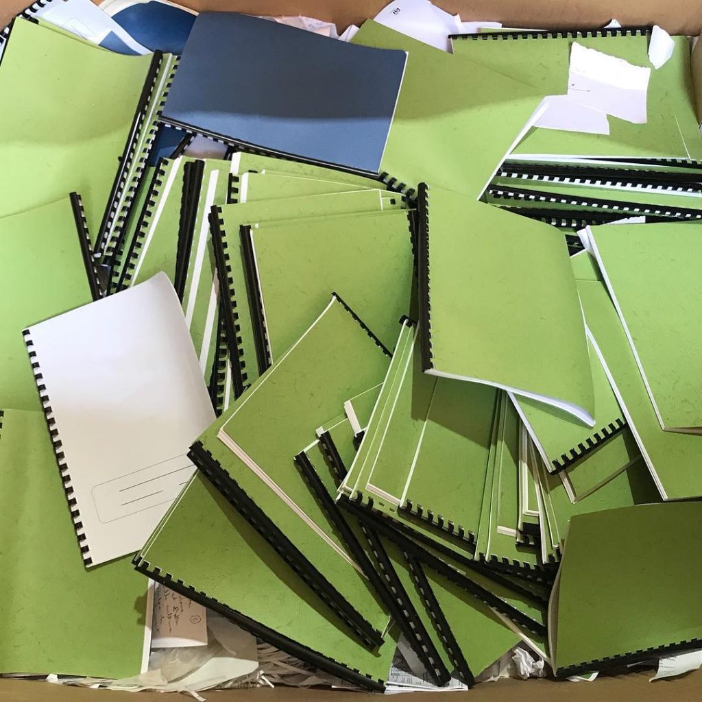 Collected book binders and office documents prepared for recycling or disposal in Singapore.