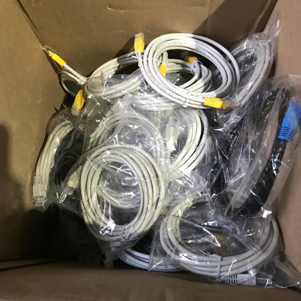 Box of telecommunication data cables prepared for recycling in Singapore, including Cat5 and Cat6 ethernet cables with plastic packaging.